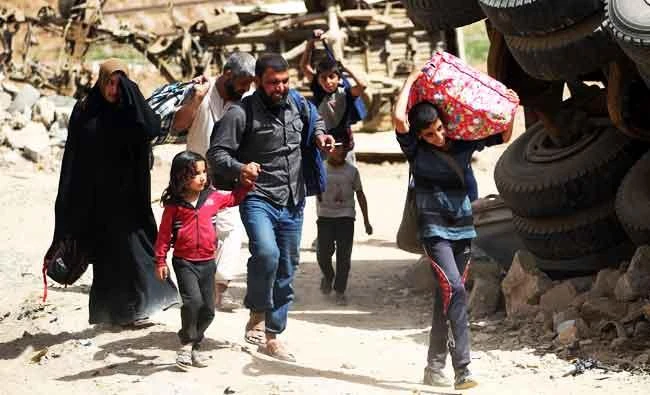 Displaced Iraqis evacuate from western Mosul's al-Islah al-Zaraye neighbourhood on Saturday during the government forces' military offensive to retake the area from Daesh group fighters. (AFP)