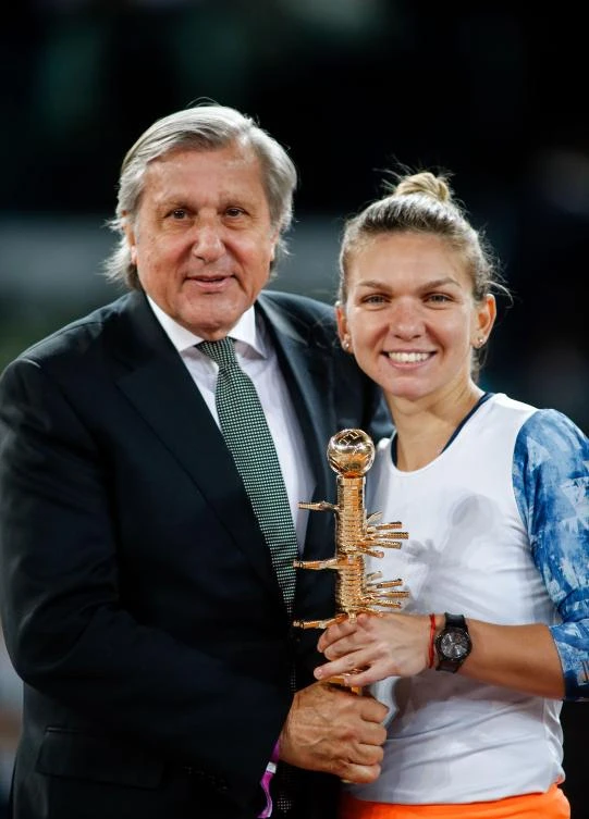 Romanian tennis player Simona Halep, right, poses with Romanian former tennis player Ilie Nastase after winning to French tennis player Kristina Mladenovic during the WTA Madrid Open final match in Madrid on Saturday. (AFP)