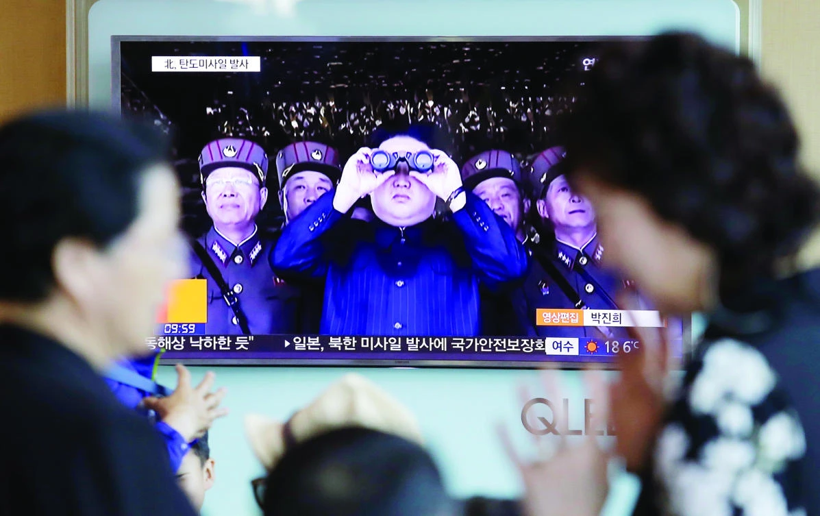 A TV news program shows a file image of North Korean leader Kim Jong Un flanked by his generals, at the Seoul Railway Station in Seoul, on Sunday. (AP)