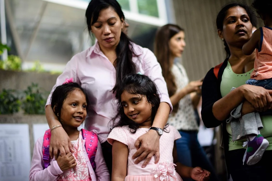 Sri Lankan refugee Nadeeka (R) holds her baby boy Danath as her daughter Sethumdi (front C) stands with Keana (front L), daughter of Filipino refugee Vanessa Rodel (back C), as they meet the press outside the Immigration Tower in Hong Kong on May 15, 2017. (AFP)