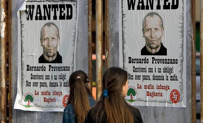Posters calling for the capture of an Italian mafia boss is shown in this file photo in the island of Sicily. Italian police on Monday announced the arrest of 68 people, including a priest and the head of a volunteer group called “Mercy” for allegedly conniving with a major mafia clan in skimmeing millions in public funds destined for a migrant welcome center. (AFP file photo)