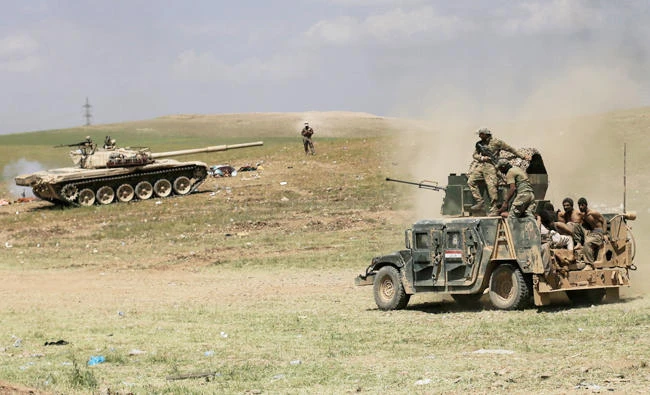 Iraqi forces transport suspected Daesh fighters on a humvee outside western Mosul. (AP)