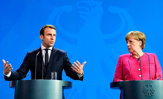 German Chancellor Angela Merkel and French President Emmanuel Macron address a joint press conference in Berlin. (AFP)