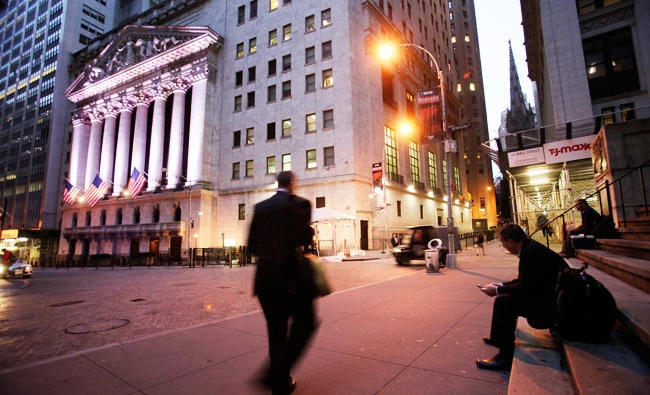 In this Oct. 8, 2014 file photo, a man walks to work on Wall Street, near the New York Stock Exchange, in New York. (AP)