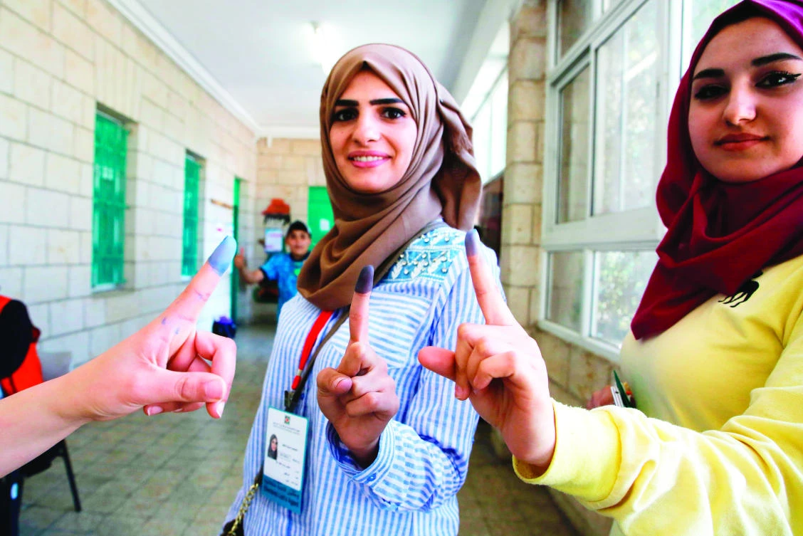Women show their ink-stained fingers after casting their ballots during the municipal elections in the West Bank city of Ramallah Saturday. (AFP)