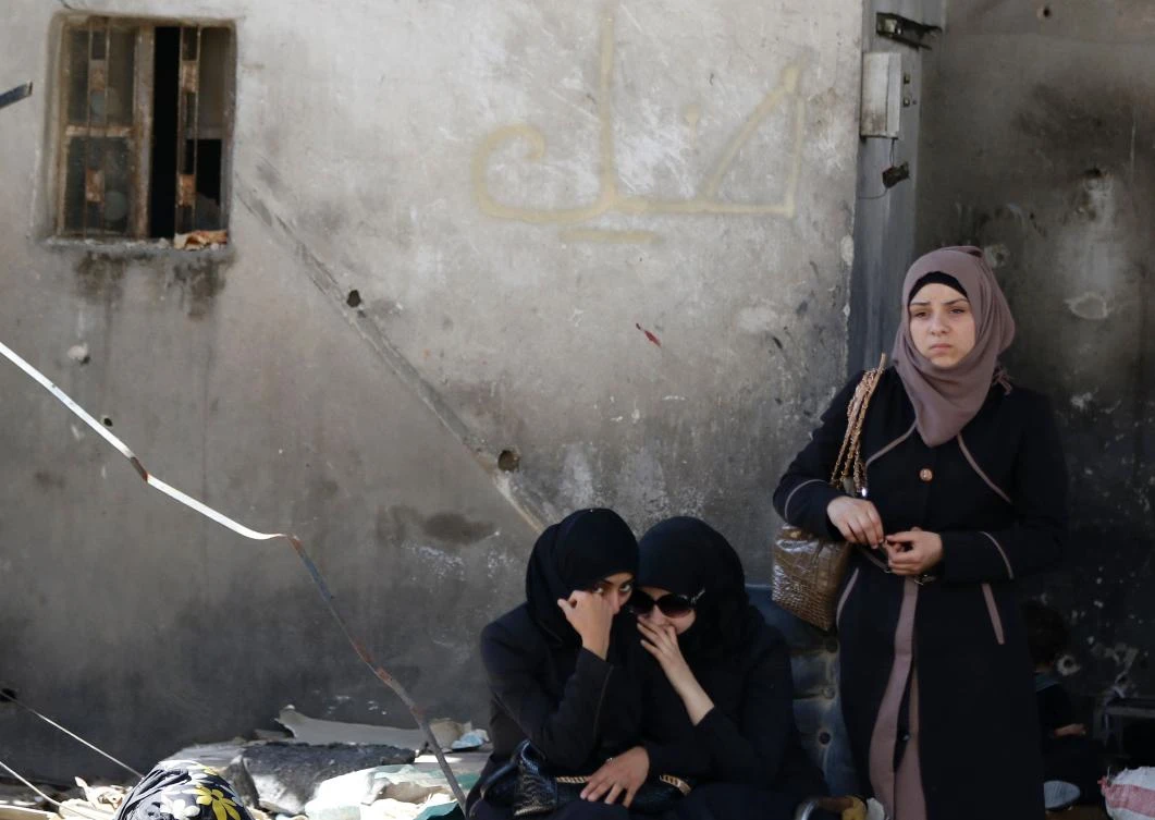 Residents of Al-Qaboun, a previously opposition-held northeastern suburb of Damascus, wait in an area designated by the Syrian regime for their cases to be processed after the suburb was retaken by regime forces. (AFP)