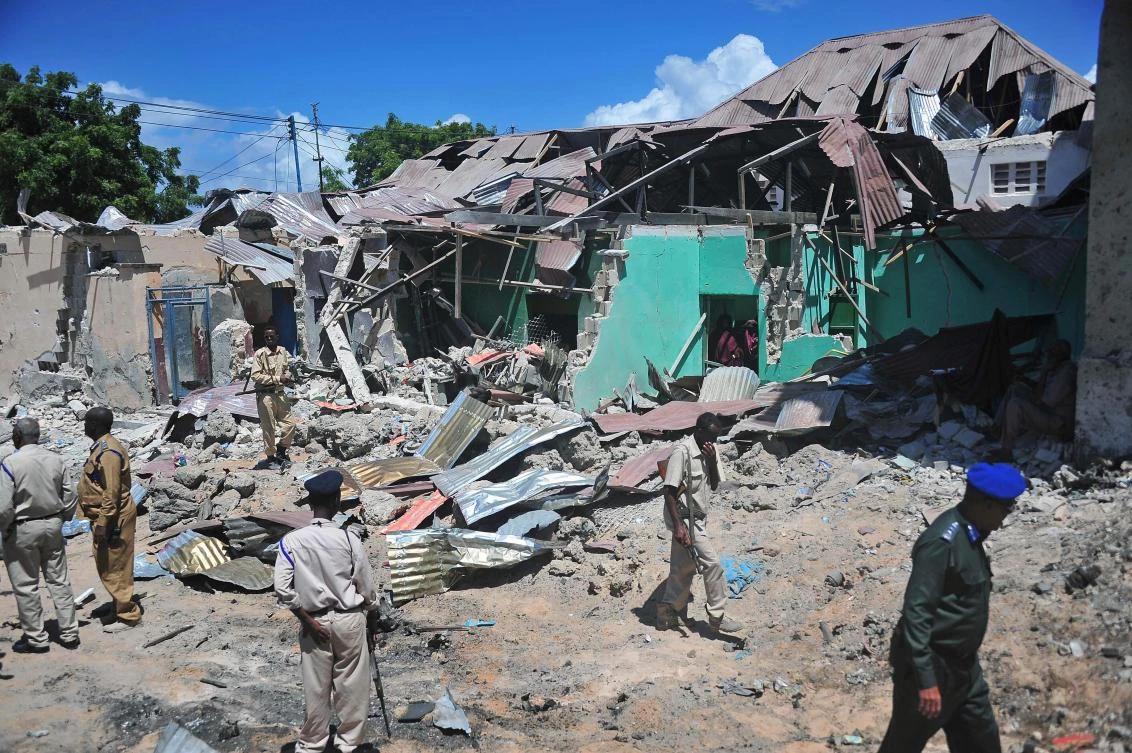 Somali security officers walk at the scene of a car bomb attack in Mogadishu, which killed police bomb specialists trying to defuse it on Wednesday. (AFP / MOHAMED ABDIWAHAB)