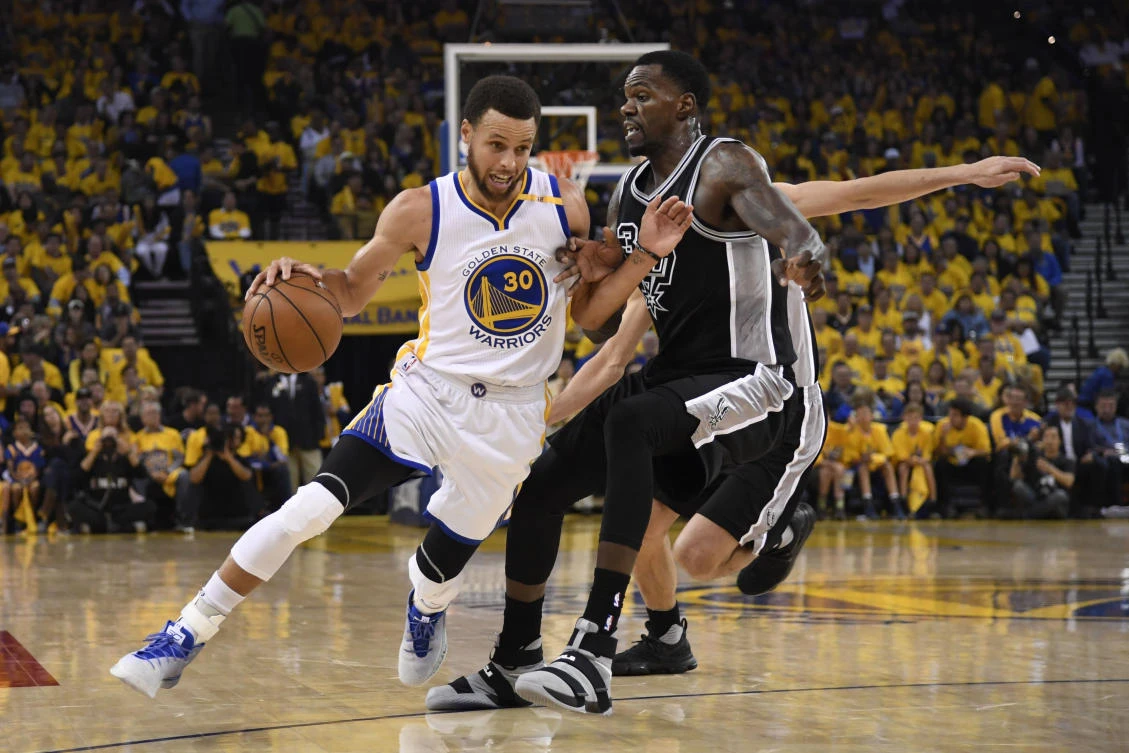 Golden State Warriors guard Stephen Curry dribbles the basketball against San Antonio Spurs center Dewayne Dedmon during the first quarter in Game 2 of the Western Conference finals of the NBA Playoffs at Oracle Arena on Tuesdya. (USA TODAY Sports)