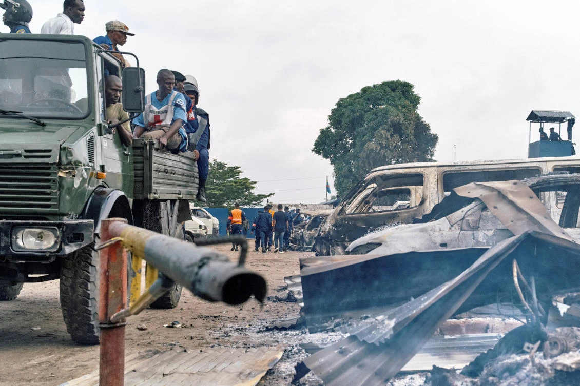 Security personnel sitting on a truck watch burned vehicles at the front gate of the Makala prison in Kinshasa, Democratic Republic of the Congo. (REUTERS/Robert Carrubba)