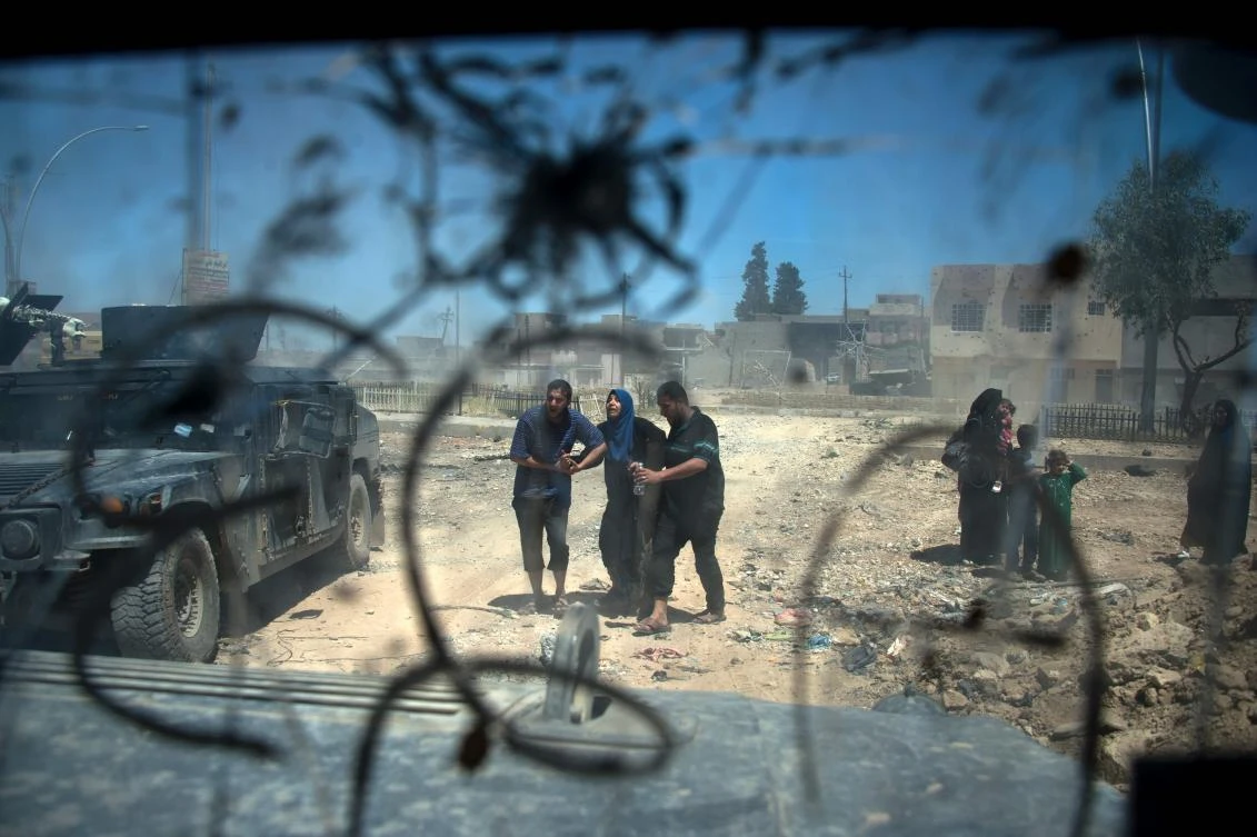 Displaced Iraqis walk after evacuating their homes in a neighbourhood of west Mosul on May 17, 2017, during an ongoing offensive from the Iraqi forces to retake the area from Islamic State (IS) group fighters. Iraqi forces pound the Islamic State group in the last pockets it controls of its former bastion west Mosul after spokesmen said the jihadist group was "on the brink of total defeat". (AFP)