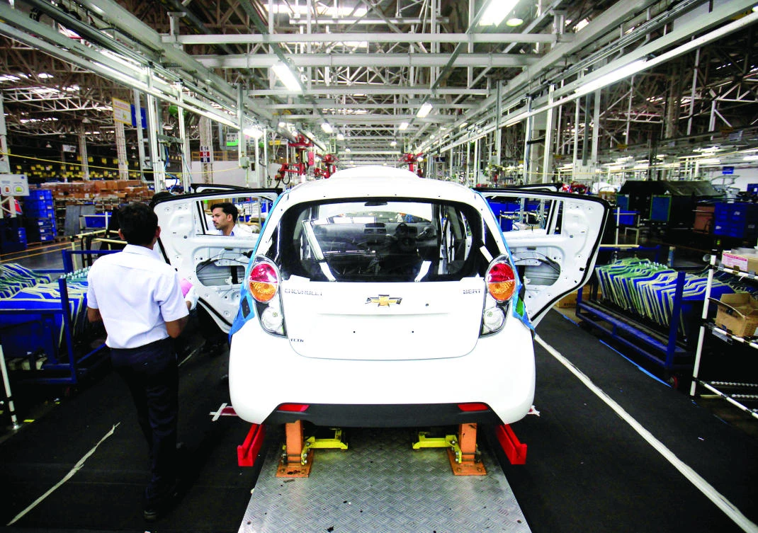 Employees work on a Chevrolet Beat car on an assembly line at the General Motors plant in Talegaon, about 118 km from Mumbai in 2012. (Reuters)