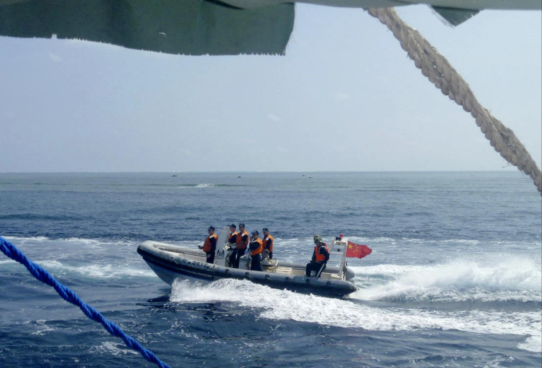 A Chinese Coast Guard boat circles a Filipino fishing boat near Scarborough Shoal in the South China Sea. (Renato Etac via AP)