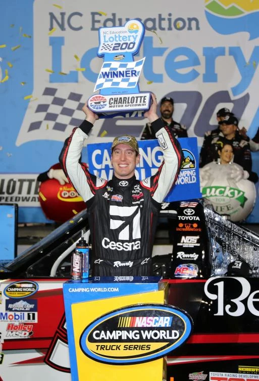 Kyle Busch, driver of the #51 Cessna Toyota, celebrates with the trophy after winning the Camping World Truck Series North Carolina Education Lottery 200 at Charlotte Motor Speedway on Friday in Charlotte, North Carolina. (AFP)