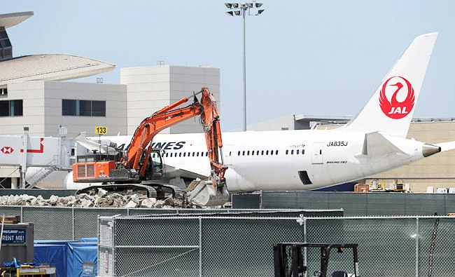 In this May 11, 2017 photo, construction workers build an addition to Tom Bradley International Terminal next to a Japan Airlines jet at Los Angeles International Airport. (AP)