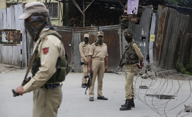 Indian policeman guard at a temporary checkpoint during a restrictions in Srinagar, Indian-controlled Kashmir, on Sunday. (AP Photo/Mukhtar Khan)