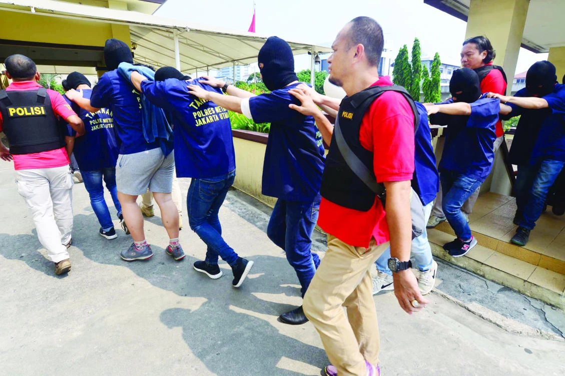 Indonesian police escort men arrested for alleged homosexual activities in Jakarta on Monday. (AFP)