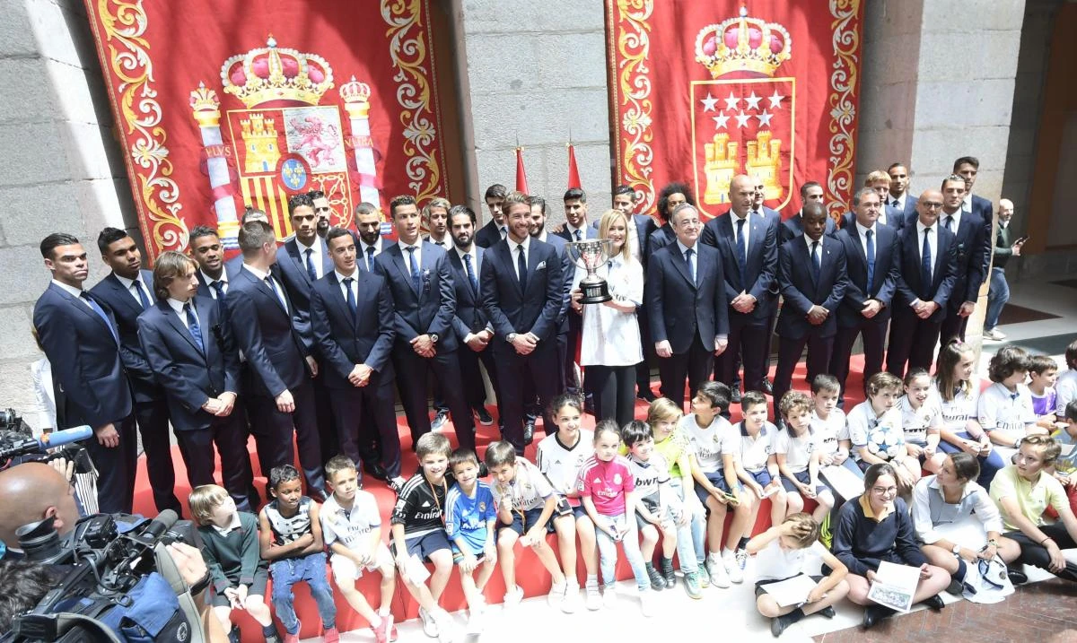 Real Madrid team poses with the president of Madrid, Cristina Cifuentes, at the Madrid Community headquarters, in Madrid on Monday during a celebration after the team won the Spanish league football tournament. (AFP)