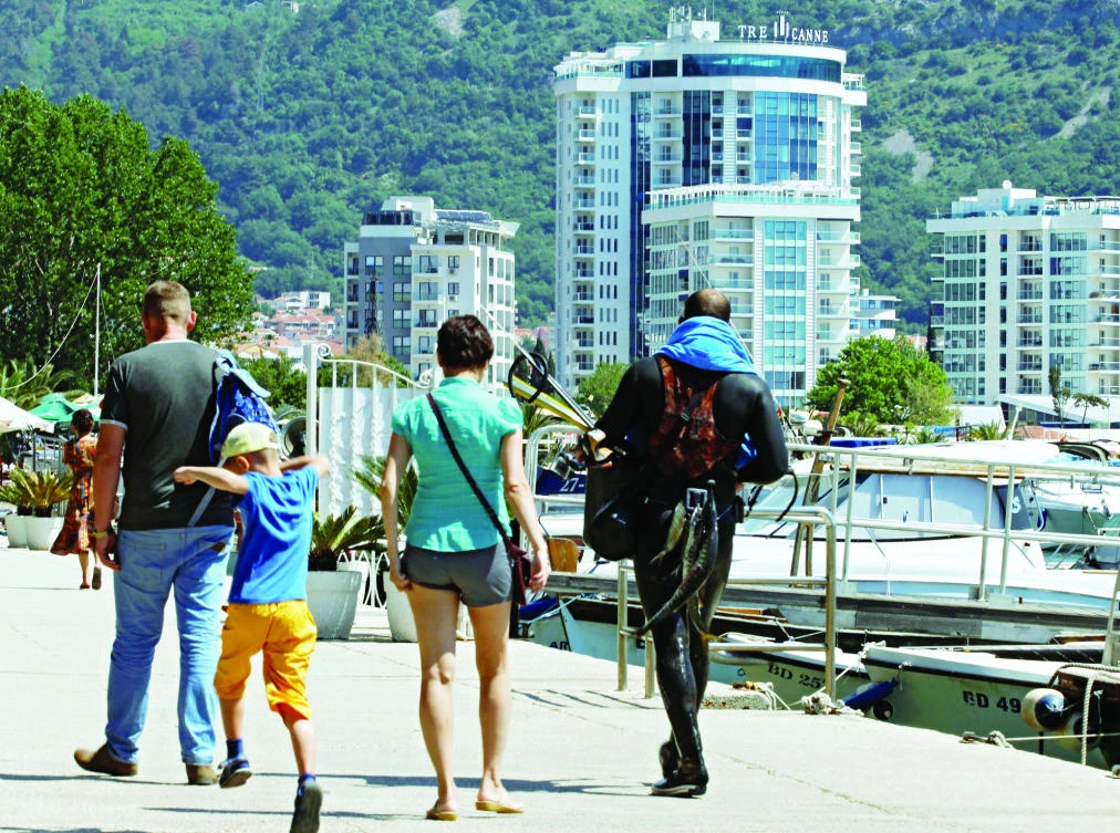 Newly-built real estates are seen behind tourists in city marina in Budva, Montenegro. (Reuters)