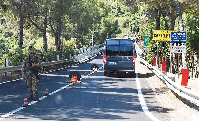 An Italian soldier stands guard on a road near Taormina on Monday in Sicily. (AFP)