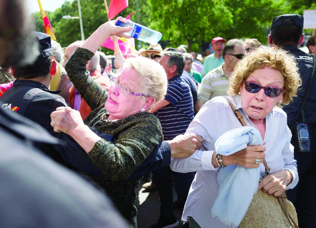 A protester throws a bottle of water at a Catalan politician during a protest against Catalan independence in Madrid, Spain. (AP)