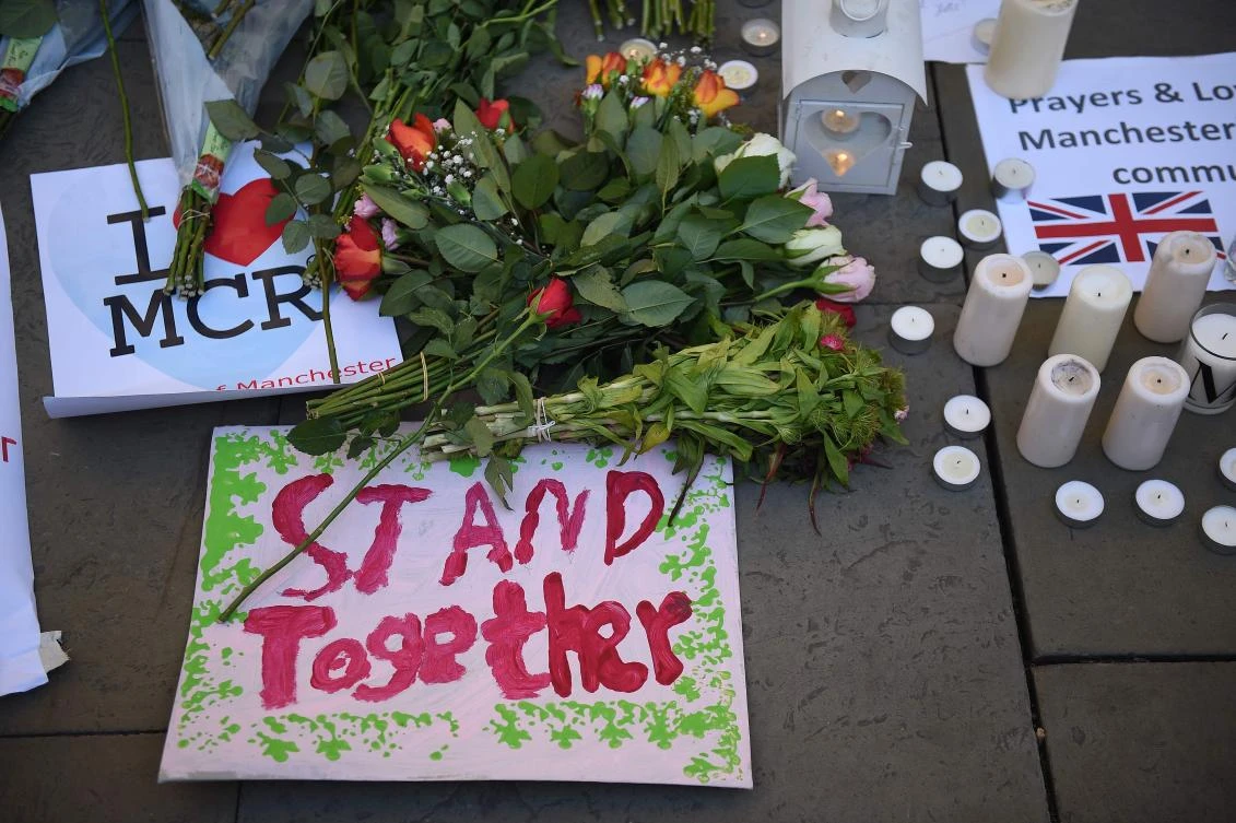 Candles, sings and floral tributes left at a vigil in Albert Square are pictured in Manchester, northwest England on Tuesday, in solidarity with those killed and injured in the May 22 terror attack at the Ariana Grande concert at the Manchester Arena.( AFP / Oli Scarff)