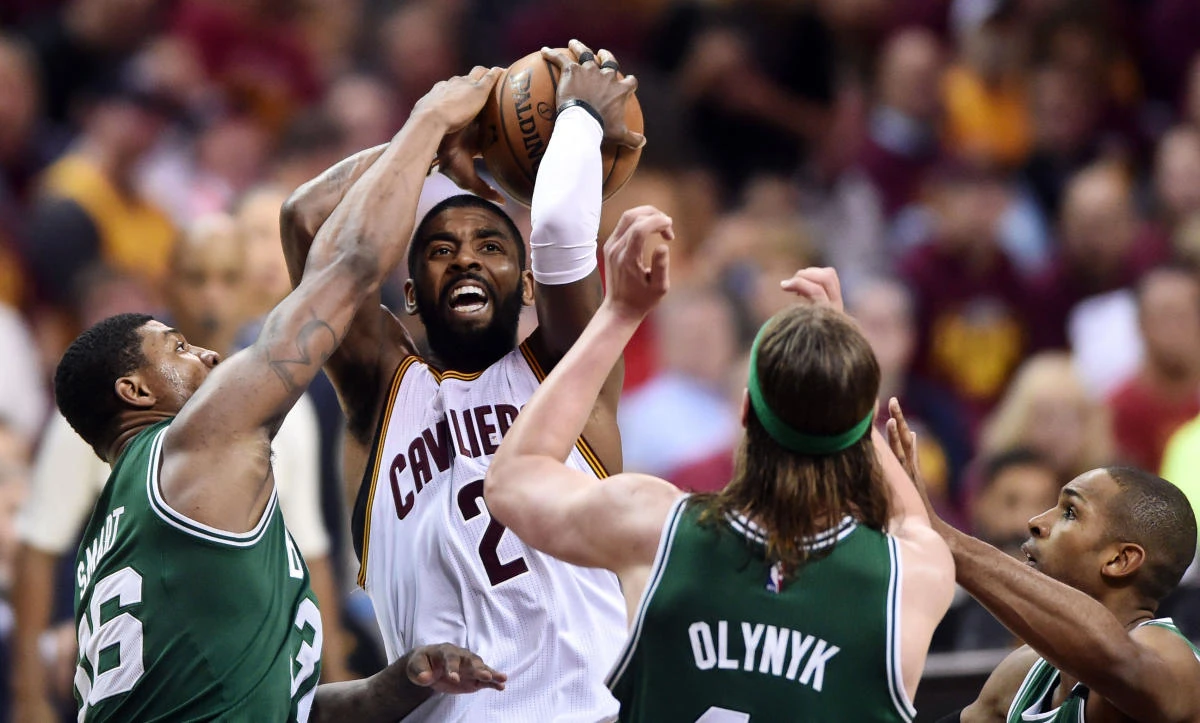 Cleveland Cavaliers guard Kyrie Irving (2) drives to the basket between Boston Celtics guard Marcus Smart (36) and center Kelly Olynyk (41) during game four of the Eastern conference finals of the NBA Playoffs at Quicken Loans Arena in Cleveland, Ohio. (Ken Blaze-USA TODAY Sports via AFP)