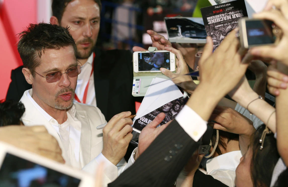 Actor Brad Pitt gives his autographs for fans upon arrival for the Japan premiere of their film "War Machine" in Tokyo, Tuesday, May 23, 2017. (AP)