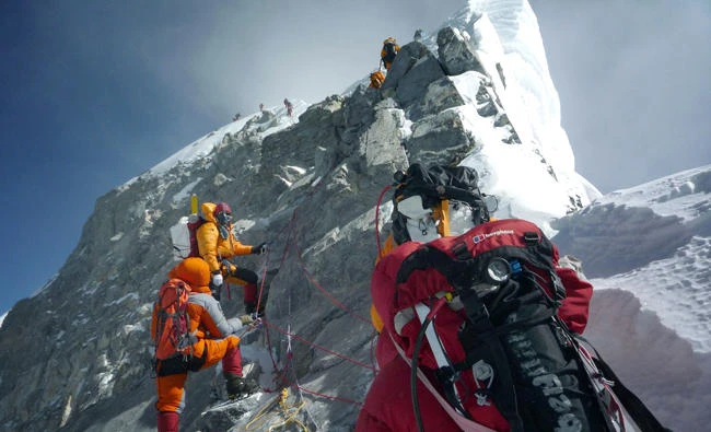 In this file photo, mountaineers walk past the Hillary Step while pushing for the summit of Mount Everest as they climb the south face of the mountain from Nepal. (AFP)