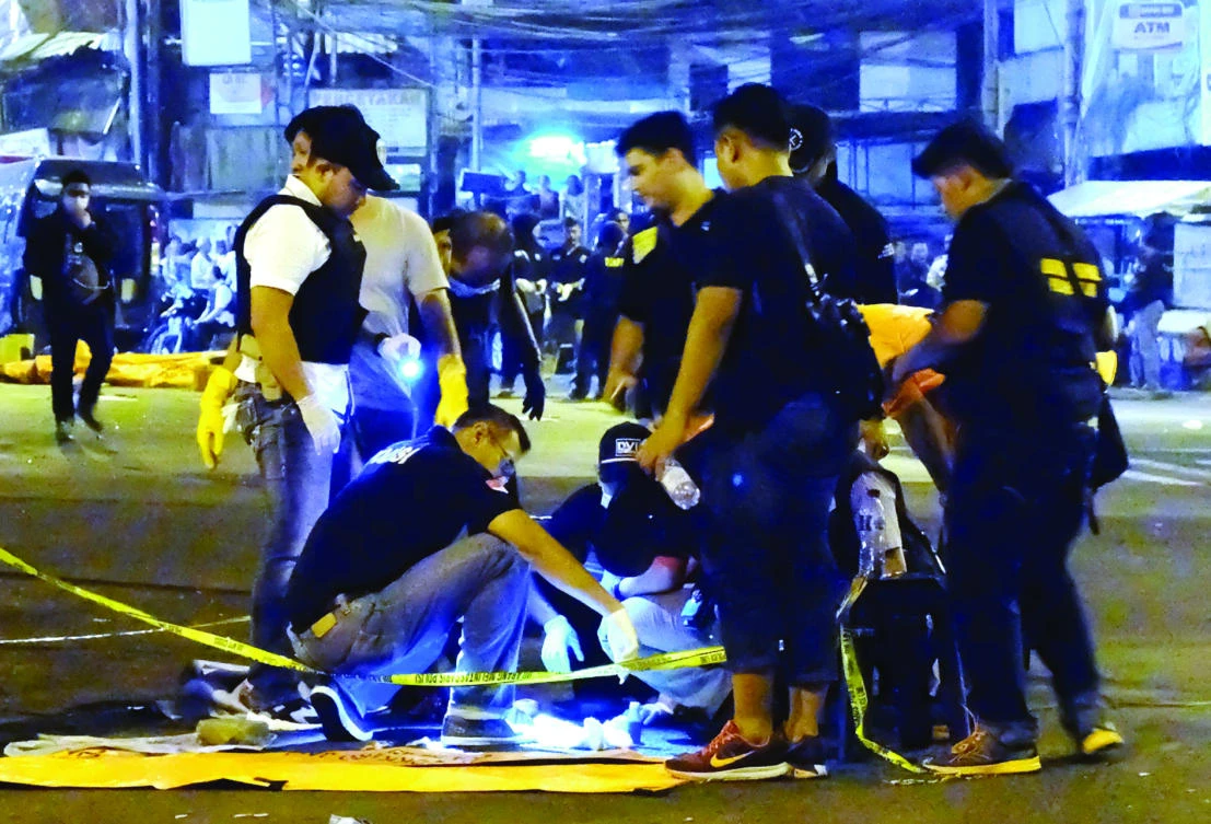 Indonesian police investigators check a body part found after a suicide bomb blast at Kampung Melayu bus terminal in Jakarta on Wednesday. (AFP)
