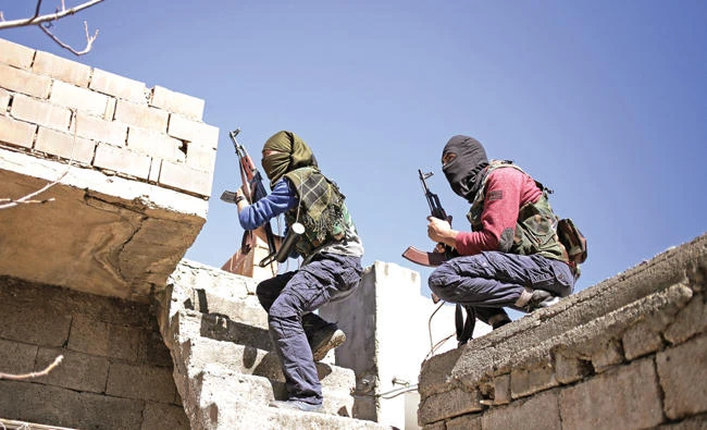 Militants from the Kurdistan Workers' Party, or PKK, run as they attack Turkish security forces in Nusaydin, Turkey, in this March 1, 2016 photo. On Thursday, two Turkish soldiers and a policeman have been killed in two separate clashes with PKK militants in eastern Turkey, officials said. (AP Photo/Cagdas Erdogan)