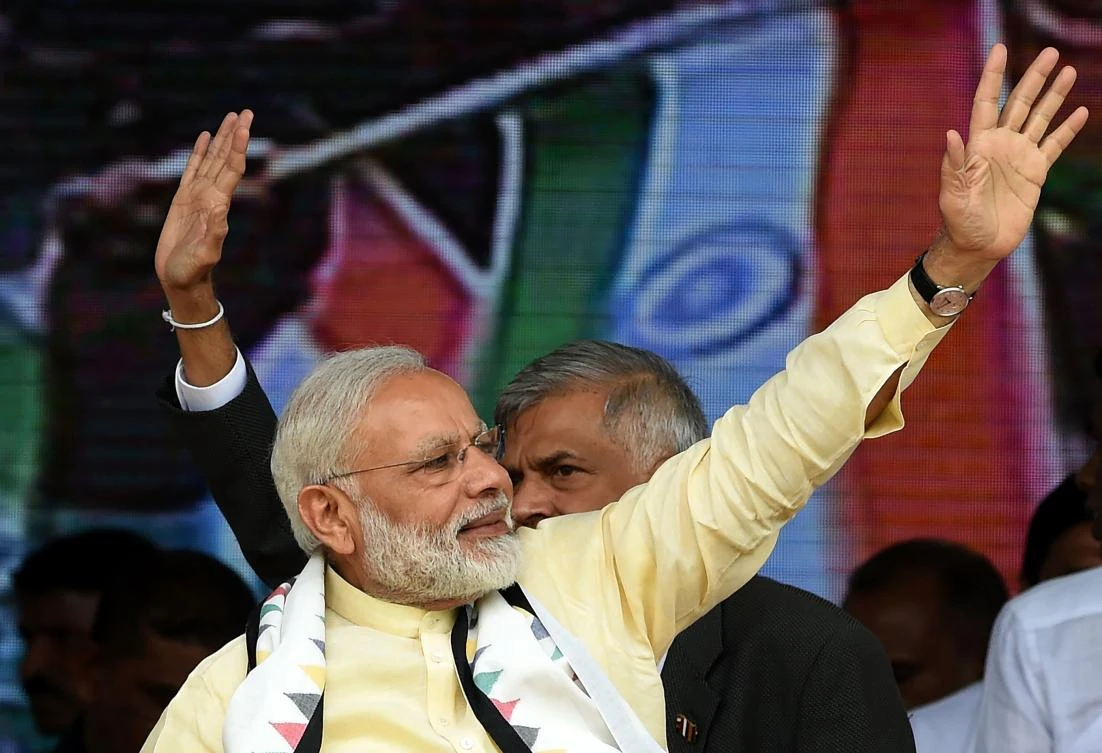 Indian Prime Minister Narendra Modi (L) and Sri Lankan Prime Minister Ranil Wickremesinghe (R) wave to supporters after addressing a public rally in the tea-growing town of Norwood, some 80kms east of Colombo on May 12, 2017.(AFP)