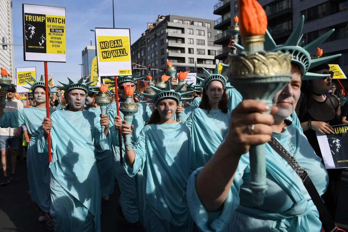 Protesters wearing Statue of Liberty costumes demonstrate in Brussels on May 24, 2017, against the US travel ban as US President Donald Trump began his two-day visit to Brussels. A US federal appeals court ruled on Thursday that the ban “drips with religious intolerance, animus and discrimination.” (AFP / Eric Feferberg)