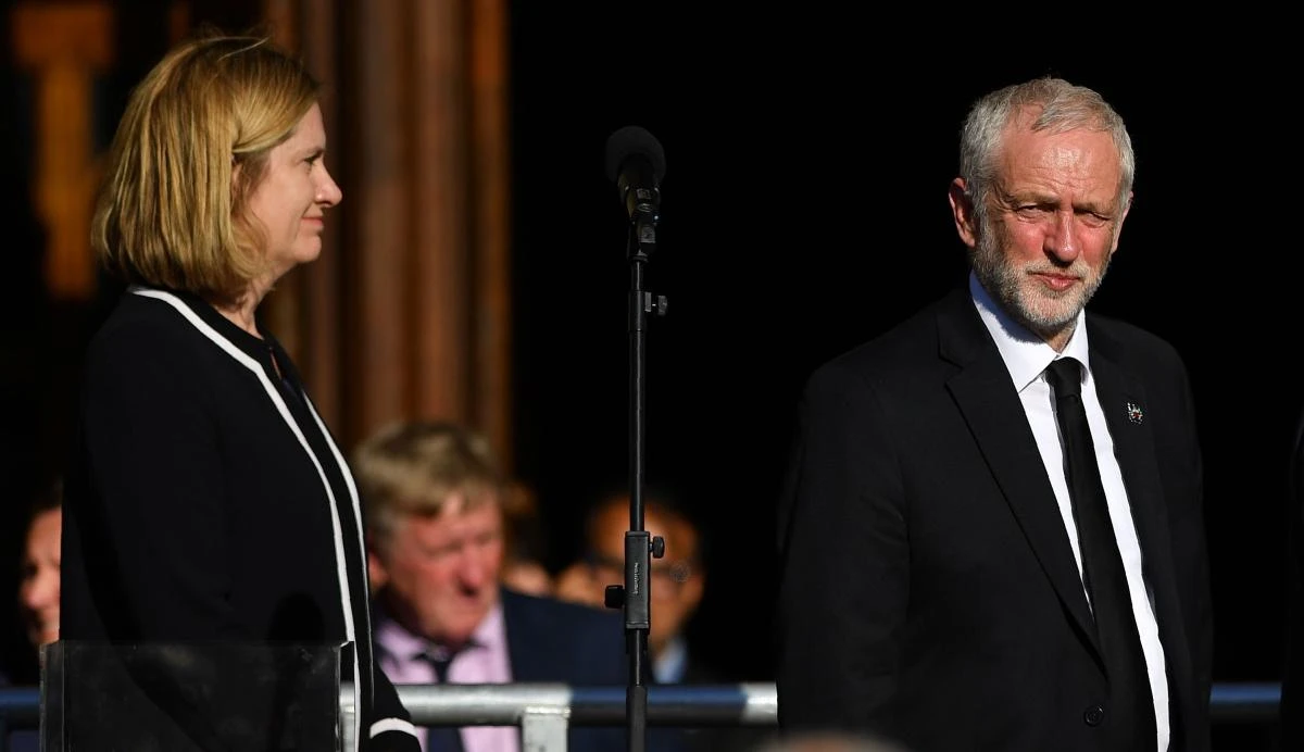 Britain's Home Secretary Amber Rudd (L) and Britain's main opposition Labour Party leader Jeremy Corbyn attend a vigil in Albert Square in Manchester, northwest England. (AFP)