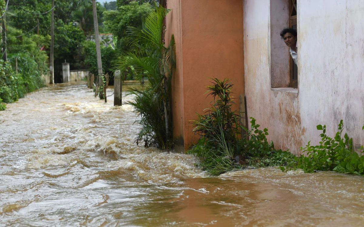 A Sri Lankan resident looks out from a building surrounded by floodwaters in the suburb of Kaduwela in the capital Colombo on May 26, 2017. Landslides and floods killed at least 25 people and left another 42 missing in Sri Lanka following heavy monsoon rains on May 26, the Disaster Management Centre said. / AFP / Ishara S. KODIKARA