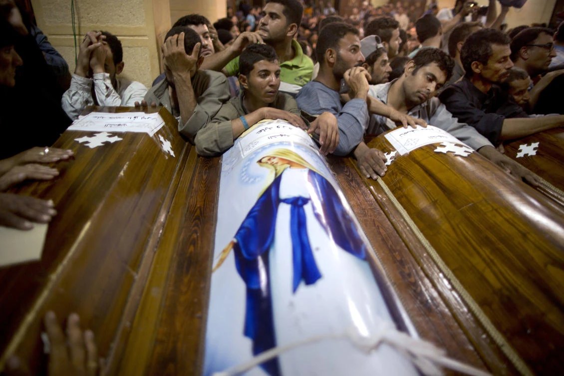 Relatives of Coptic Christians who were killed during a bus attack, surround their coffins, during their funeral service, at Abu Garnous Cathedral in Minya, Egypt, Friday, May 26, 2017. (AP)