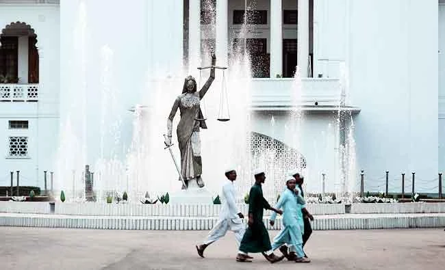 In this Feb. 28, 2017 photo, Bangladeshi Muslim boys walk past a Lady Justice statue at the Supreme Court complex in Dhaka, Bangladesh. (AP)