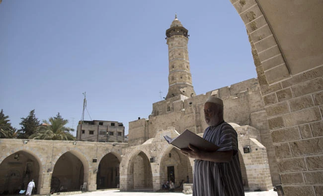 A Palestinian man reads the Qur'an on the first day of fasting in the Muslim holy month of Ramadan, at the al-Omari mosque in Gaza City, on May 27, 2017. (AFP)
