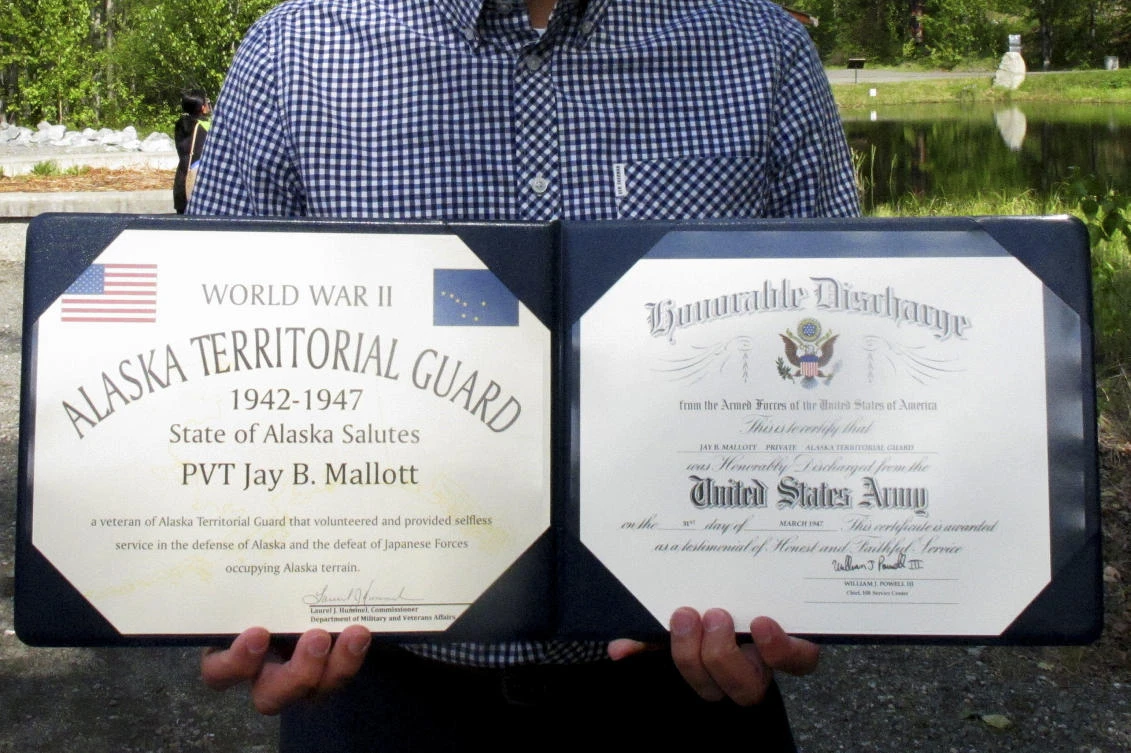 Ben Mallott holds his late grandfather Jay Mallott’s honorary discharge papers for his service in the Alaska Territorial Guard, in Anchorage, Alaska, on Friday. (AP)