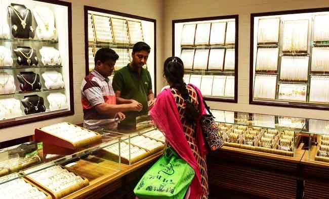 This photo taken on May 24, 2017 shows a shopper browsing in a gold jewelry shop in Dhaka. (AFP)