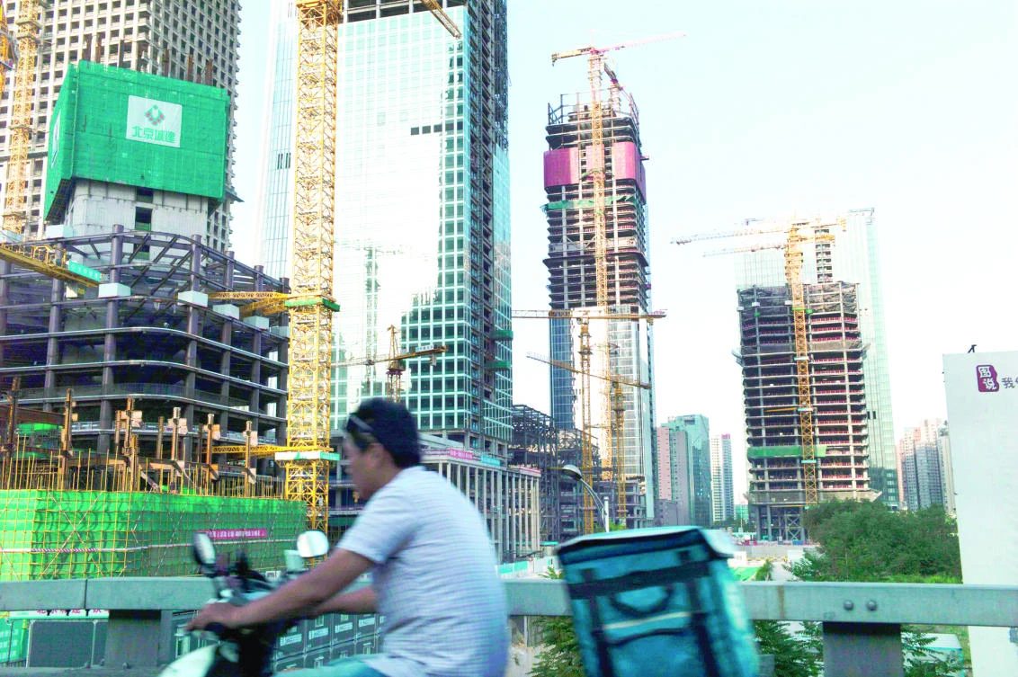 High-rise buildings under construction are seen near Beijing’s central business district. Moody’s on May 24 slashed China’s credit rating for the first time in almost three decades citing concerns about the country’s rising debt and slowing growth but Beijing rejected the downgrade as ‘inappropriate.’ (AFP)