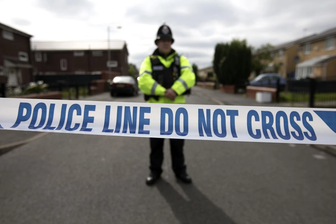 A police officer guards the entrance to a street in the Moss Side area of Manchester. (AFP)