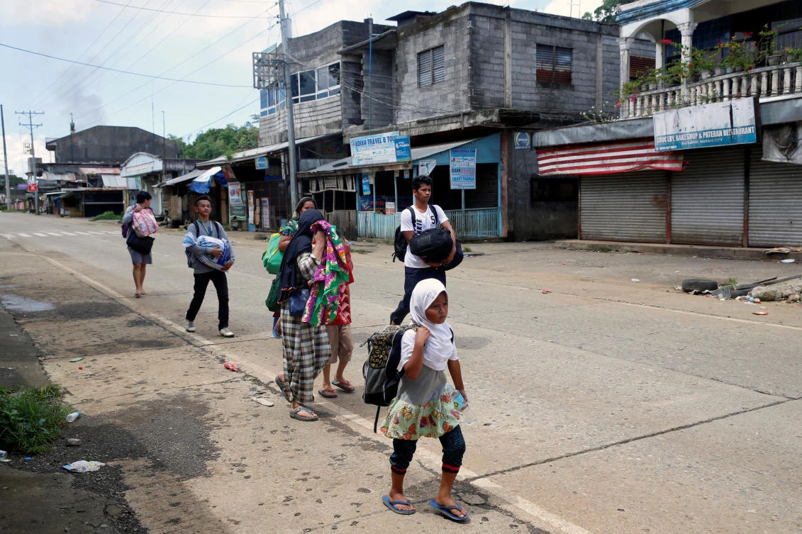 Residents flee in the residential neighbourhood of Marawi City. (Reuters)