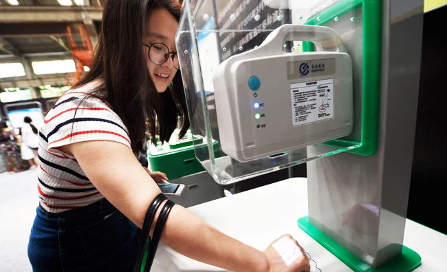 This photo taken on May 27, 2017 shows a woman trying out a machine which checks blood vessels using infrared angiography at the Hangzhou International Future Life Festival exhibition in Hangzhou in China's eastern Zhejiang province. (AFP)