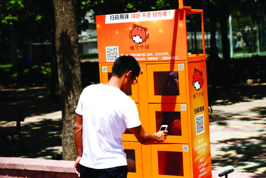 For just 2 yuan ($0.30) an hour, Nate Liu, a student at the Beijing Language and Culture University (BLCU), rents a basketball from a courtside vending machine by scanning a barcode on his smartphone. (Reuters)