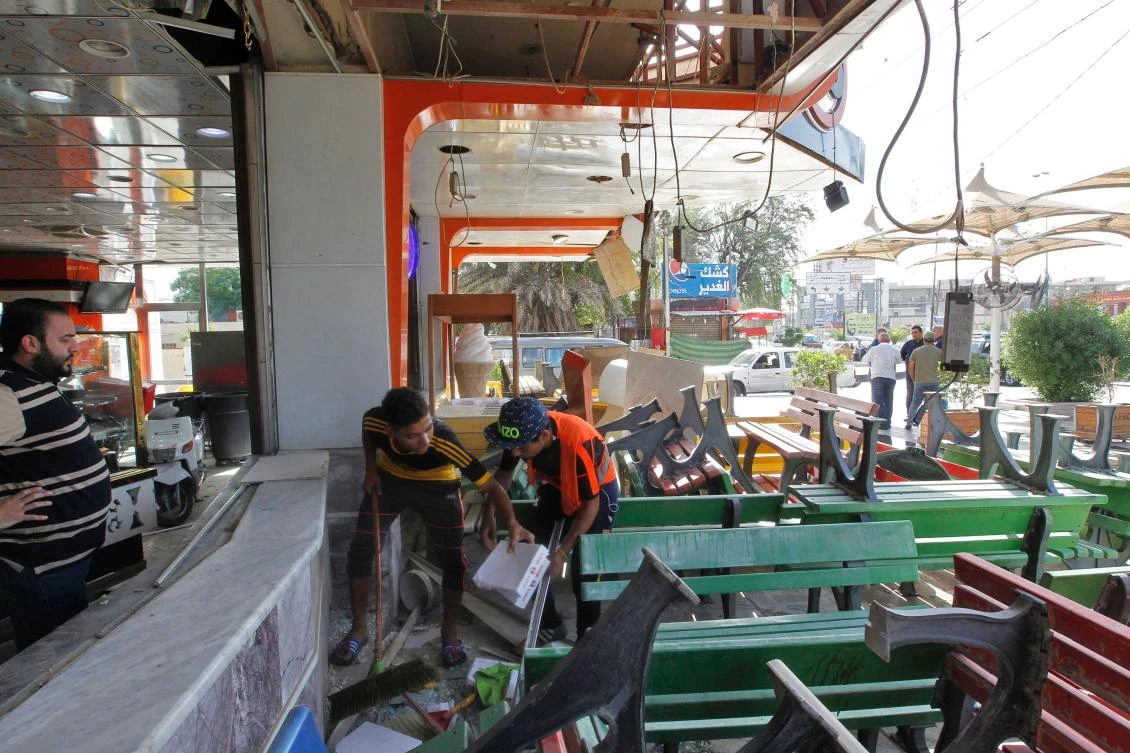 Iraqis check an ice cream shop in Baghdad's Karrada district in the aftermath of a car bom explosion on May 30, 2017. (AFP)