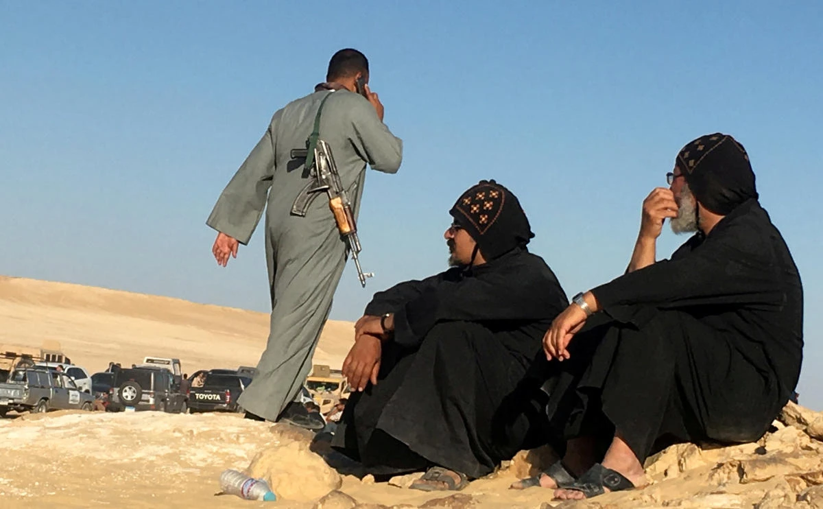 Monks look at an armed policeman following an attack by gunmen on a group of Coptic Christians traveling to a monastery in MINYA, southern Egypt, on May 26, 2017. (REUTERS/Mohamed Abd El Ghany/File Photo)