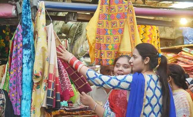 Indian customers browse at a shop selling women's suits and wedding outfits in a market in Amritsar on Tuesday. (AFP)