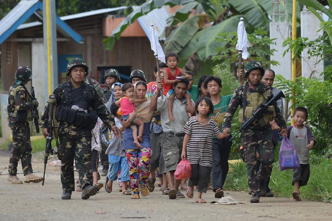 Philippine troops escort rescued civilians at a village on the outskirts of Marawi City on Wednesday. (AFP)
