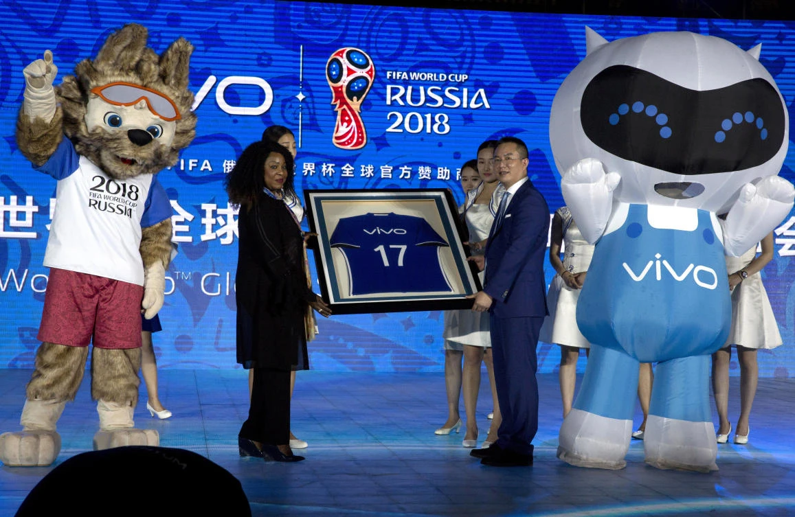 Senior Vice President of Vivo, Ni Xudong, right, holds up a jersey with FIFA's Secretary General, Fatma Samoura during a ceremony to announce the Chinese smartphone brand Vivo's sponsorship of the FIFA soccer World Cup at the Imperial Ancestral Temple in Beijing, China, Wednesday. The six year contract makes Vivo the official smartphone brand of the 2018 and 2022 FIFA World Cup tournaments. (AP)