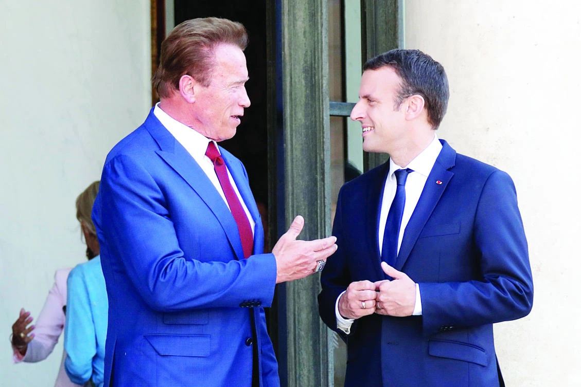 French President Emmanuel Macron speaks with former California Gov. Arnold Schwarzenegger
in Paris on Friday. (Reuters)